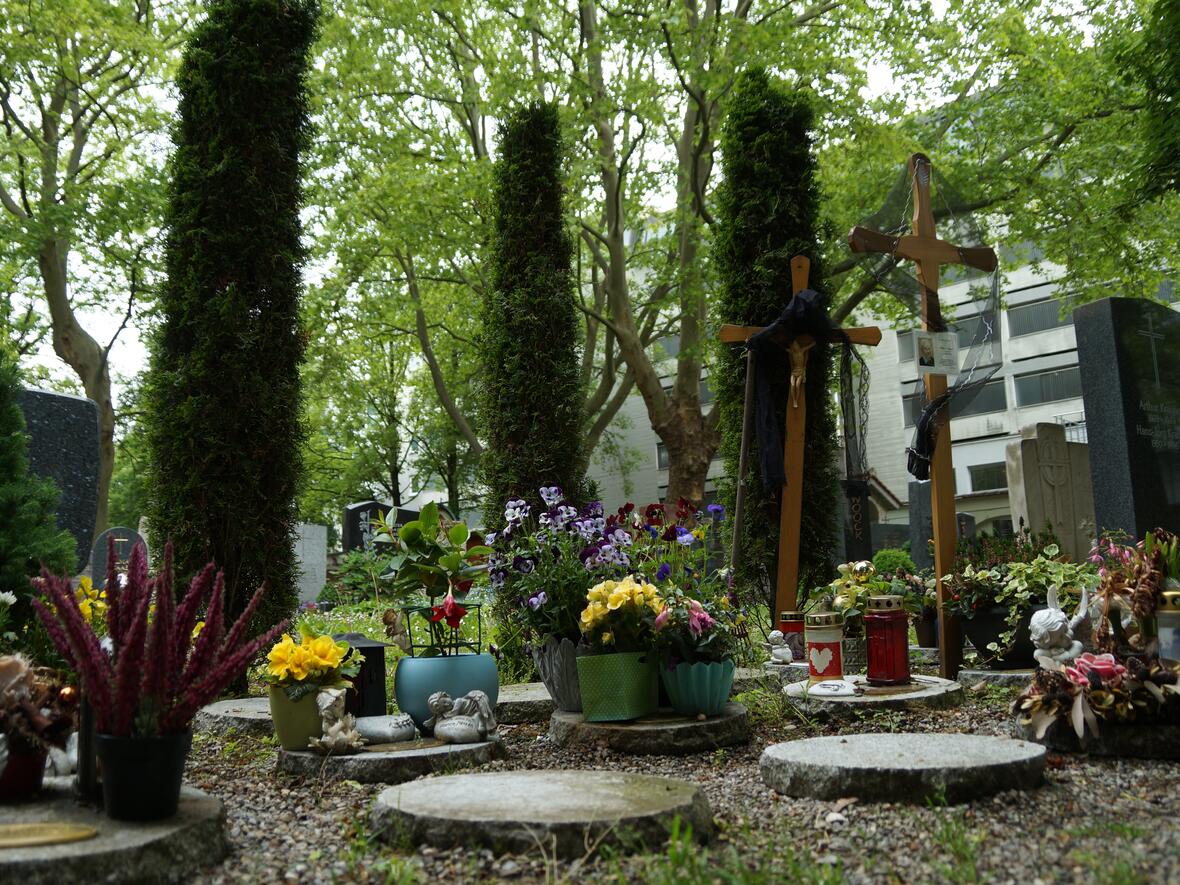 An der Grabanlage Baumurnenfeld sind auf Urnenplatten Erinnerungsgegenstände abgestellt. 